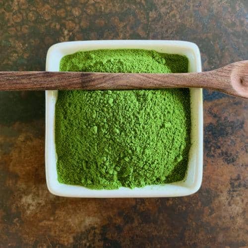 A bowl of dehydrated spinach powder is a gorgeous green.