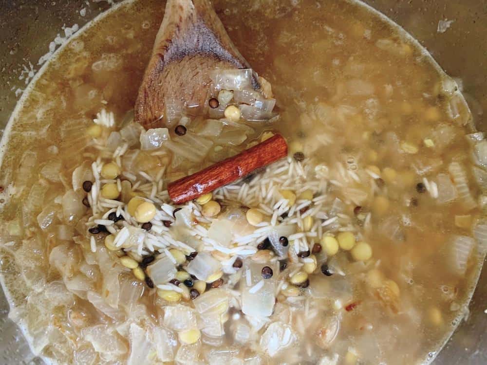 Water is added to the golden onions, spices, lentils and rice before pressure cooking.