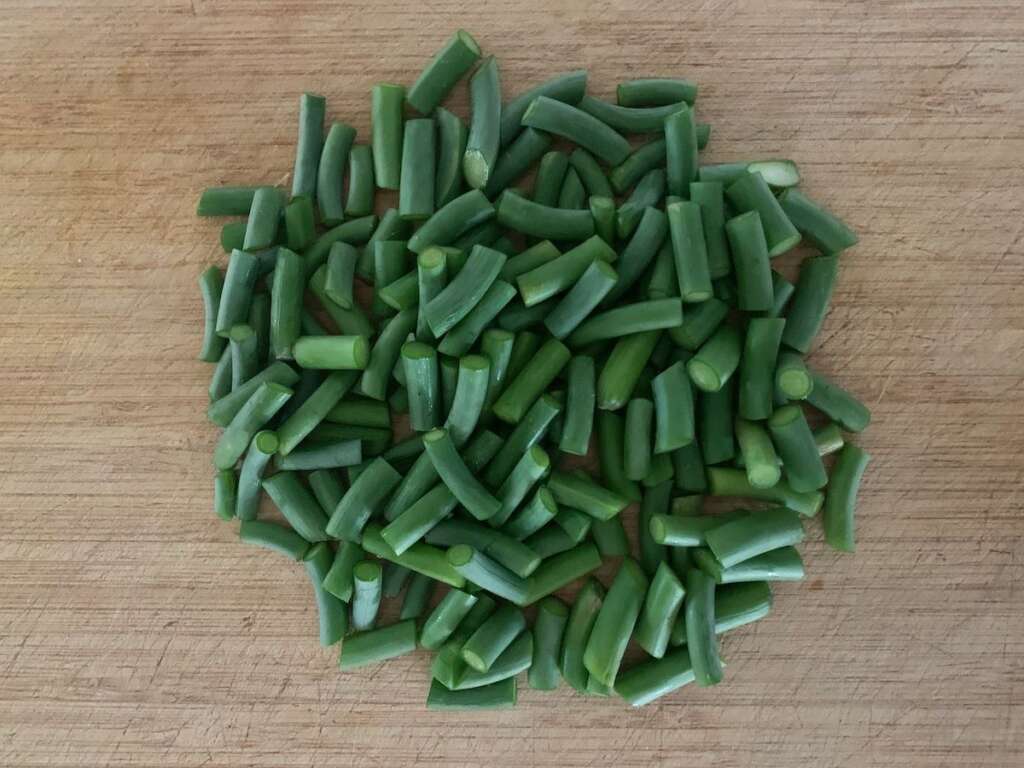 Garlic scapes are cut into 1/2" slices to load into the dehydrator.