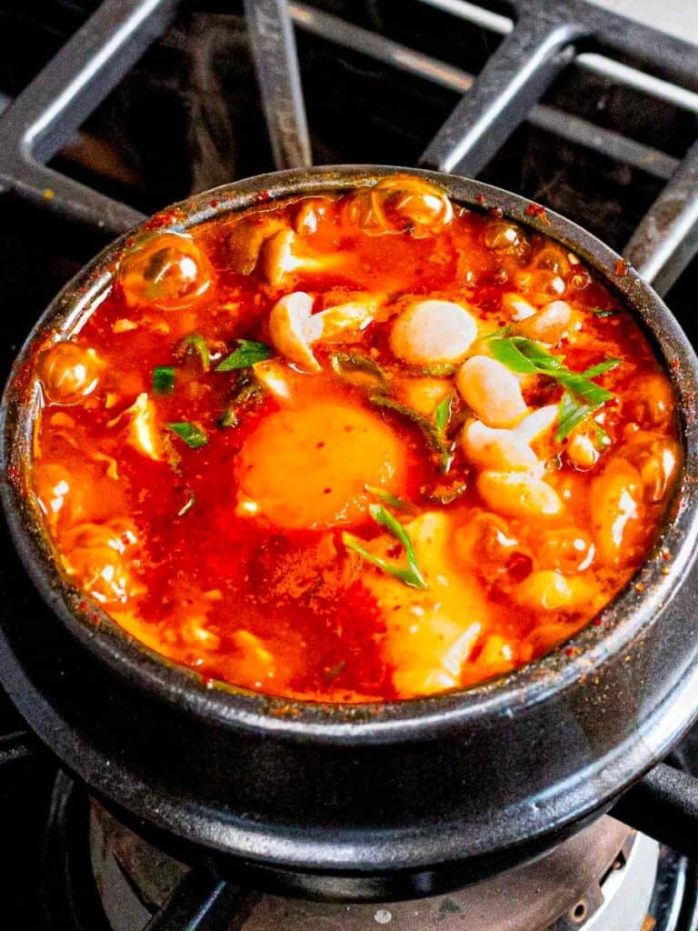 Soondubu Jjigae is a stew made from soft tofu and can be cooked over the campfire for a smoky flavor. 