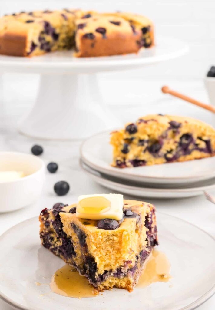 Blueberry cornbread adds a lovely twist to the usual. These slices are topped with butter and dotted with berries.