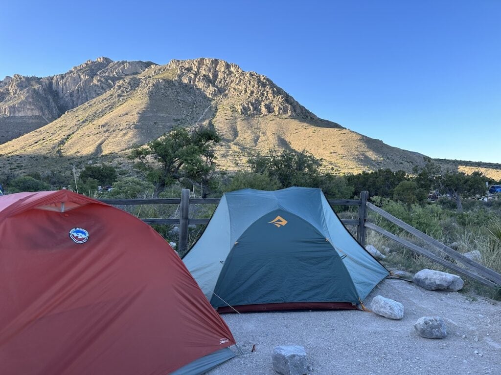 Two tents sit at the base of the mountains in the campsite at GuadalupeMountains National Park.