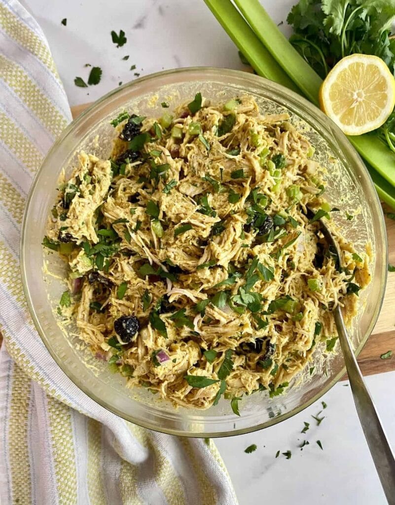 This curry chicken salad is topped with herbs and awaits bread for camping sandwiches.
