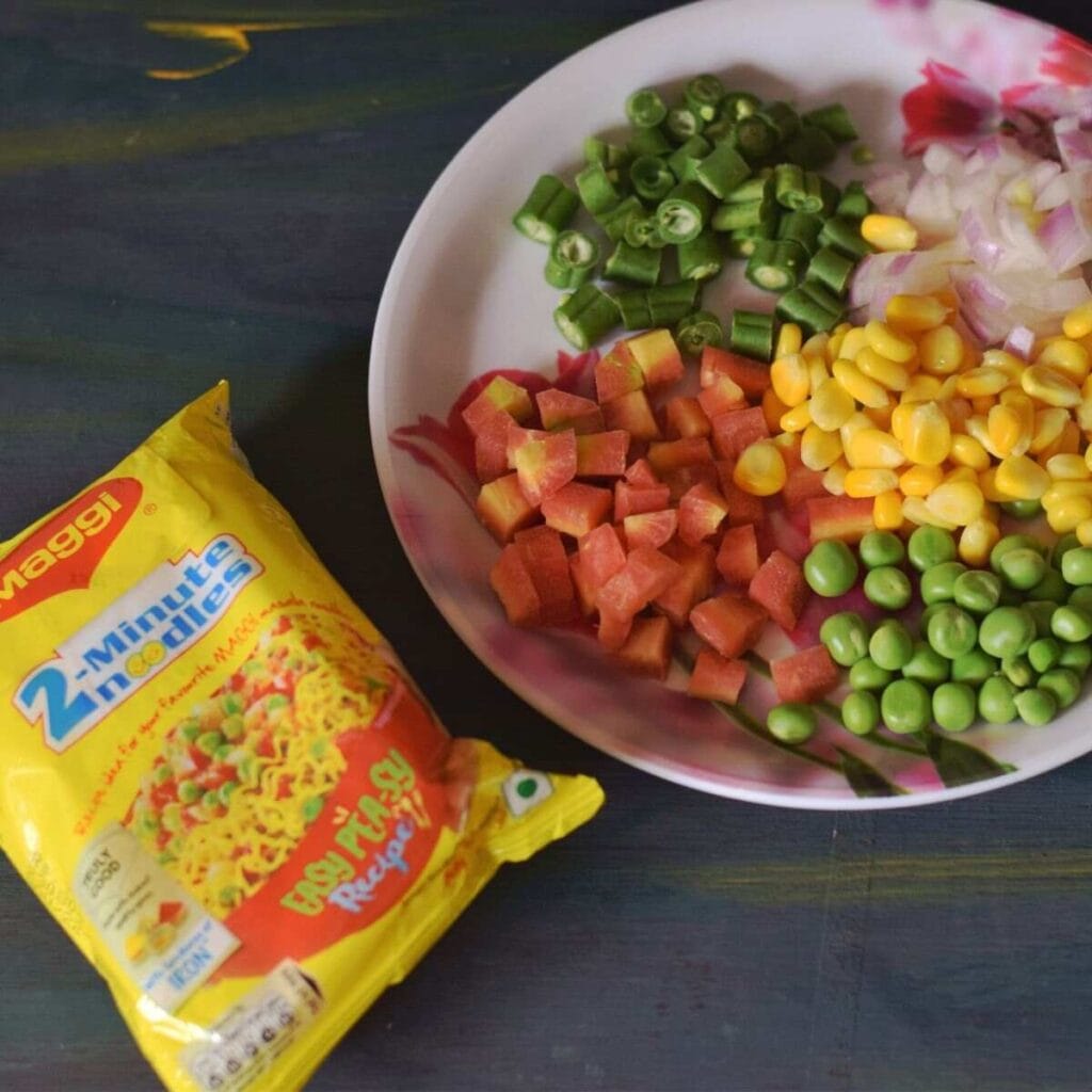 Vegetable Maggi is made with the shown veggies, carrots, green beans, onions, corn, and peas.