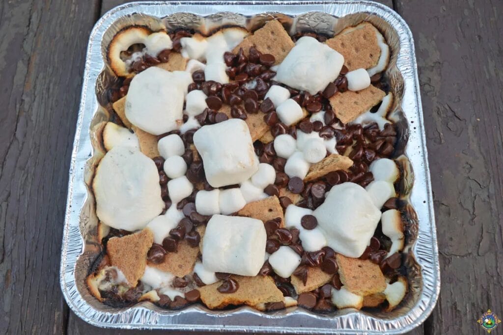 Graham crackers are topped with marshmallows and chocolate chips - they get all melty and gooey cooked over the campfire.