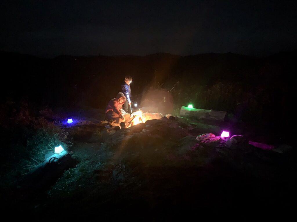 Camping and enjoying a bonfire is magic in the cooler months in Vermont. Colorful lanterns surround the area near the bonfire to light the path for us.