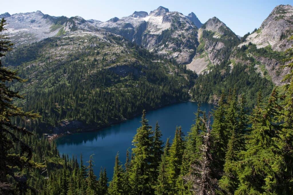 This is North Cascades National Park. The pristine blue lake is surrounded by tall mountains and lush forests.