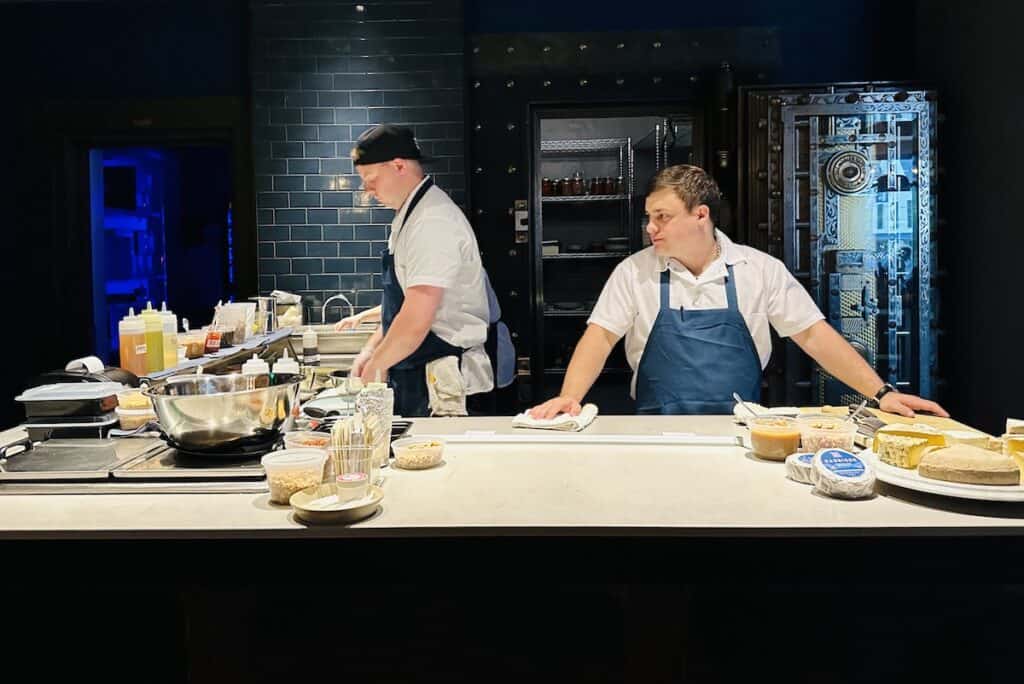Two chefs stand a prep counter creating plates of local cheeses for customers at Hen of the Wood in Waterbury VT.